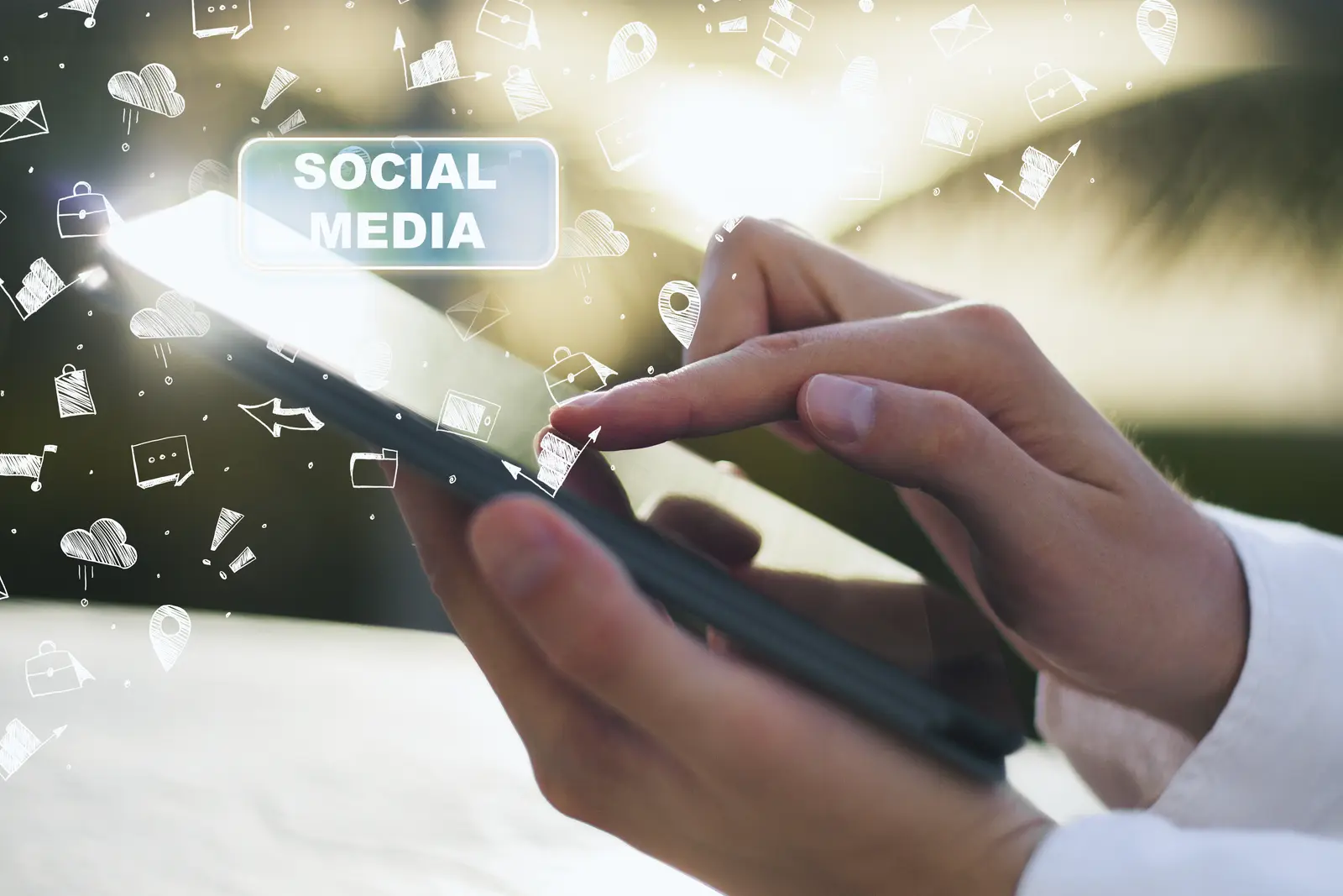 Hands holding a tablet displaying 'SOCIAL MEDIA' with floating illustrated icons of clouds, arrows, and content shapes